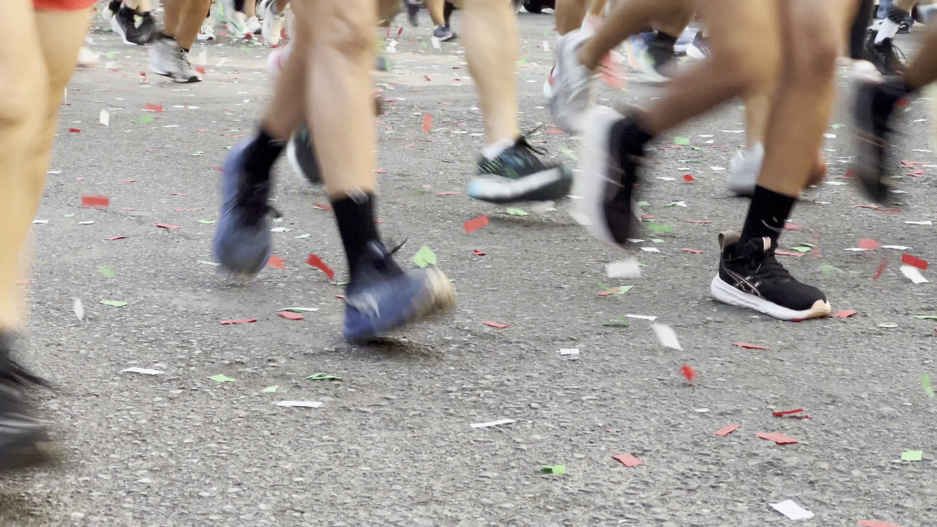 Lopers aan de start tussen de confetti